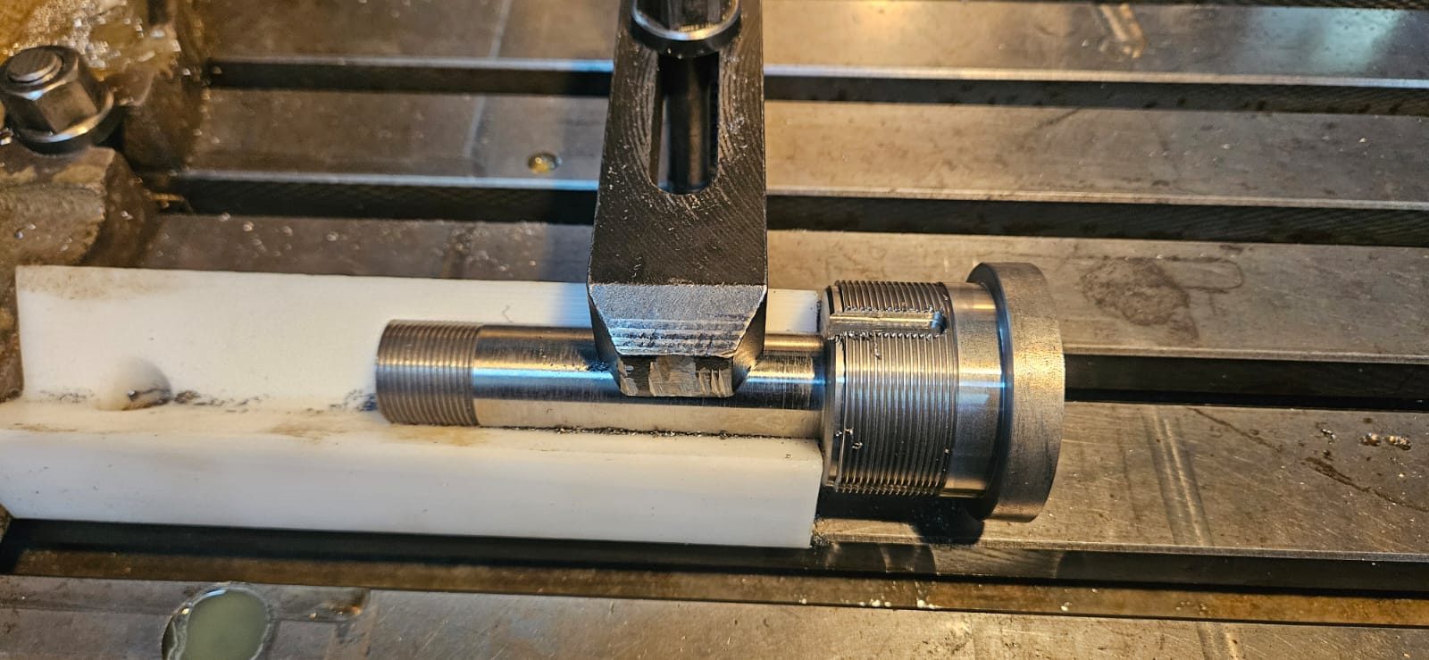 Close-up of a threaded component being measured on the mill table